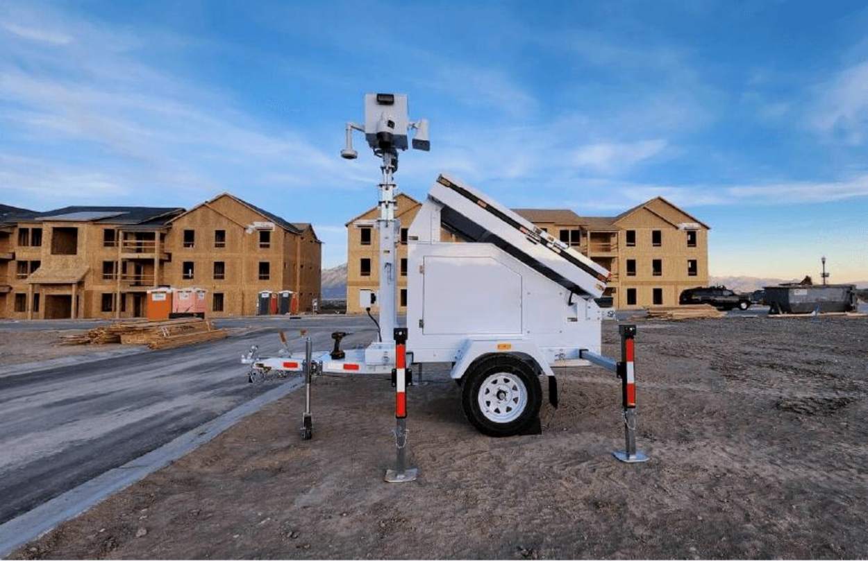 An Eagle 360 solar surveillance trailer deployed on a residential construction site, mast raised with cameras mounted at the top.